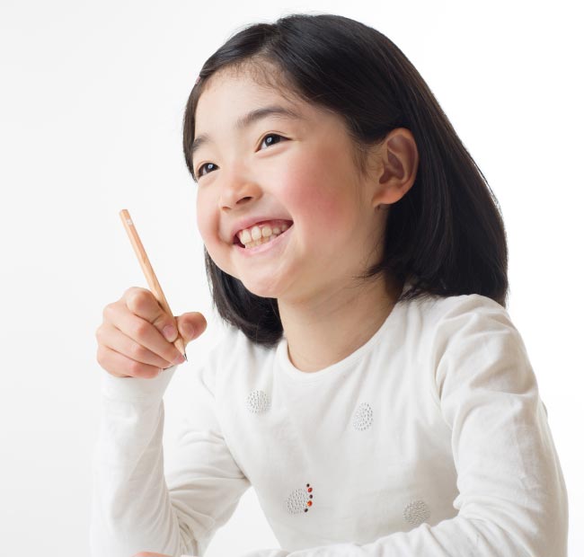 写真:笑顔で勉強中の小学生