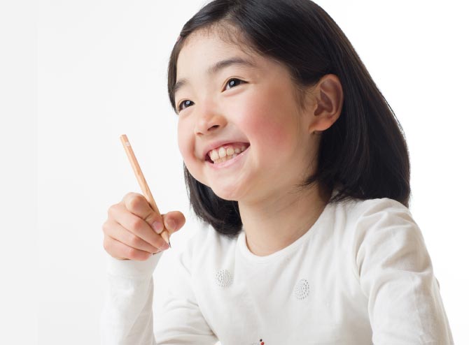 写真:笑顔で勉強中の小学生